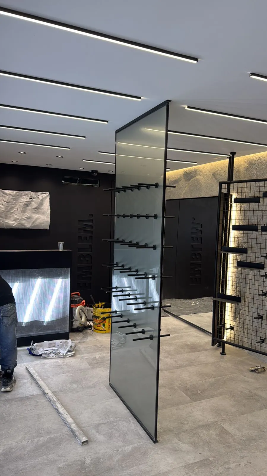 Showroom de acabados con paneles de vidrio templado y texturas en piedra natural con iluminación cálida